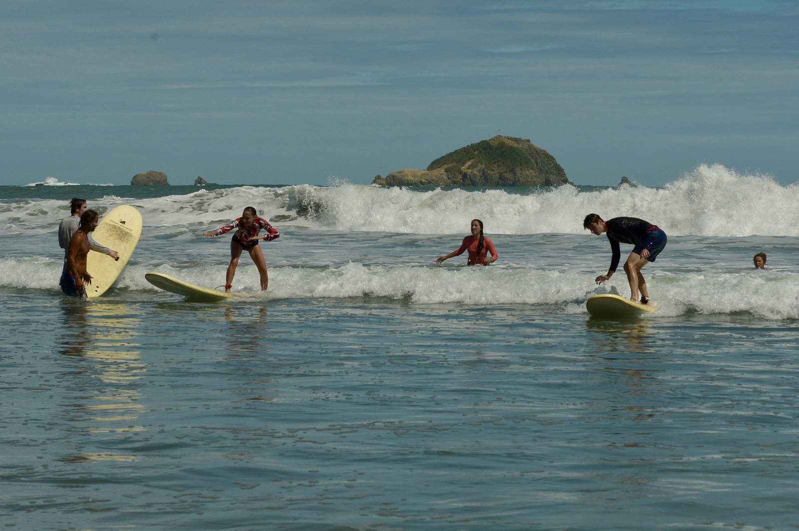 Group surf lesson with students riding waves in Manuel Antonio, Costa Rica